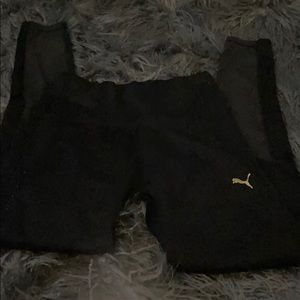 Puma leggings that are black with gold logo.
